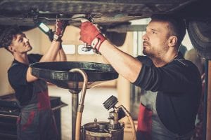 two men performing a local oil change in pembroke park